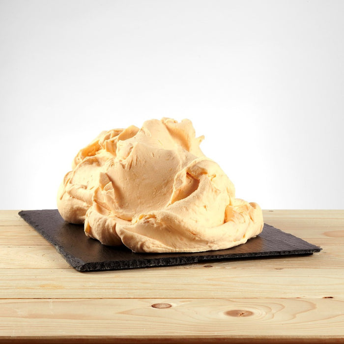 Glace saveur pêche posée, texture juteuse avec morceaux de fruit visibles.