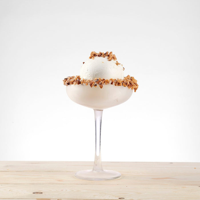 Coupe glacée décorée avec des éclats de noisettes grillées.