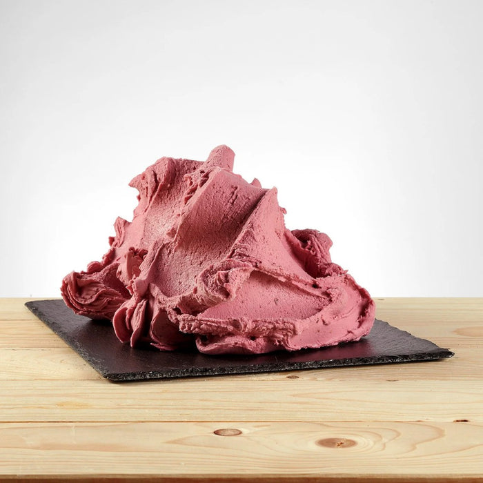 Glace à l’italienne saveur baies sauvages posée, texture fruitée avec morceaux rouges visibles.