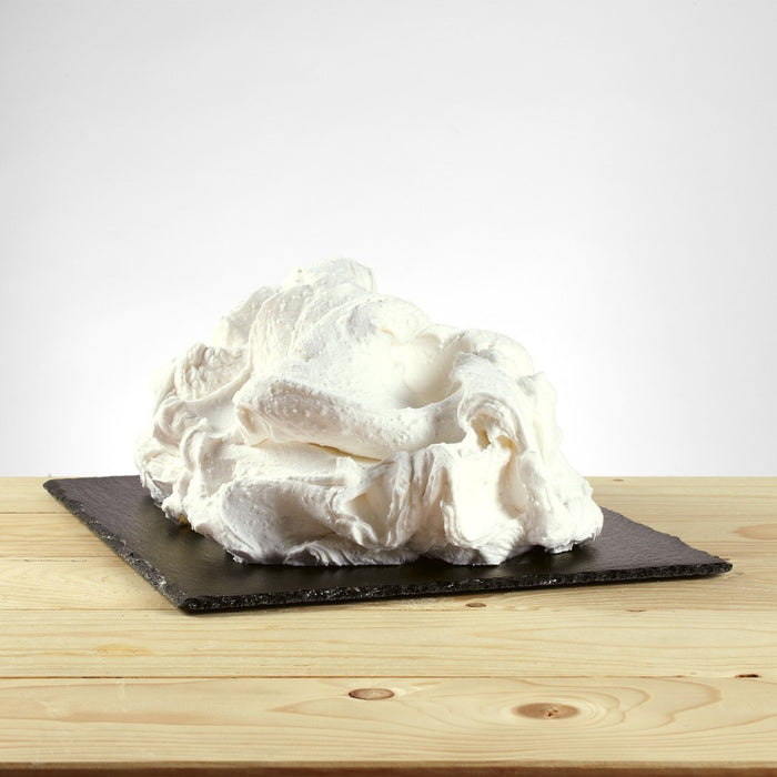Glace à l’italienne saveur noix de coco posée, texture crémeuse avec morceaux visibles.