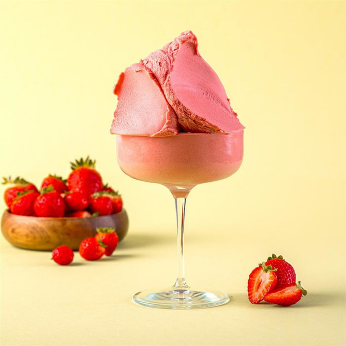 Glace fraise servie dans un verre, texture glacée et couleur vive.