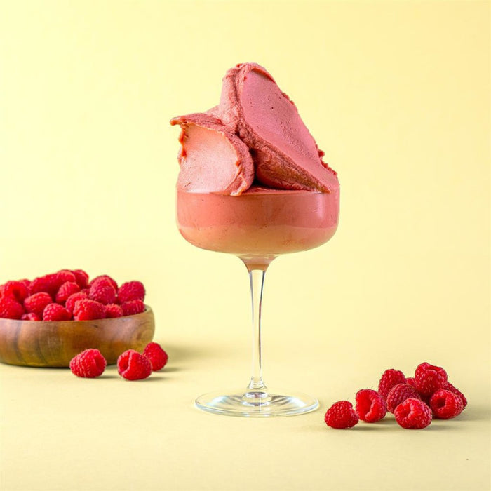 Glace framboise dans un verre, texture glacée et couleur vive.