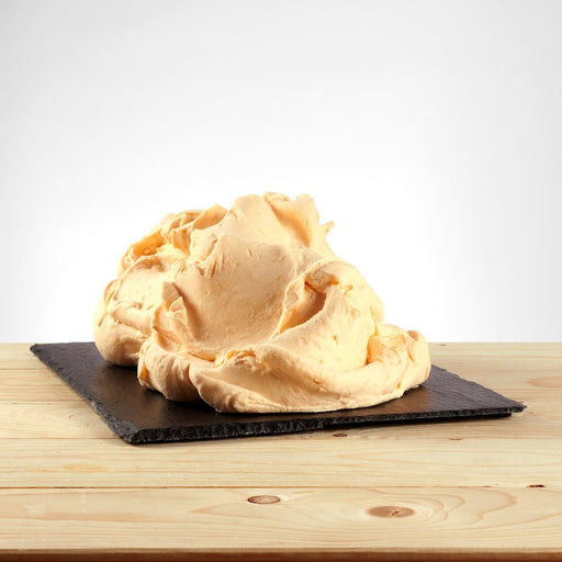 Glace saveur pêche posée, texture juteuse avec morceaux de fruit visibles.